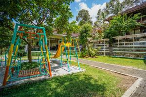 a playground with a slide in a yard at Urbanview Onengan Resort in Palang-Putih