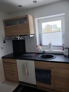a small kitchen with a sink and a window at Ferienwohnung Benzmann in Süderbrarup
