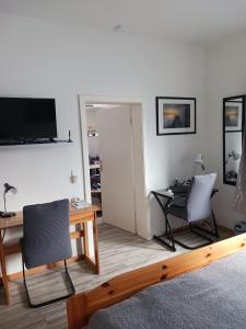 a living room with two chairs and a table and a television at Ferienwohnung Benzmann in Süderbrarup