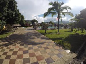 Una pasarela a cuadros en un parque con una palmera en Hotel Tacuara, en Guaduas