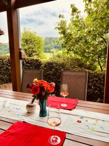 a table with two wine glasses and a vase of flowers at Ferienwohnung momentglücklich in Eggingen in Eggingen +9 photos