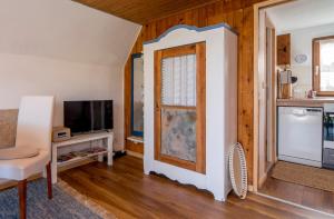 a living room with a door and a tv at Hexenhaus Finn - Nichtraucher Grundstück in Bodstedt