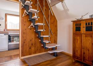 a spiral staircase in a kitchen with wooden walls at Hexenhaus Finn - Nichtraucher Grundstück in Bodstedt