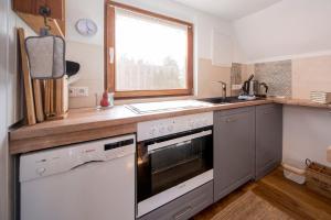 a kitchen with a stove and a sink and a window at Hexenhaus Finn - Nichtraucher Grundstück in Bodstedt +12 photos