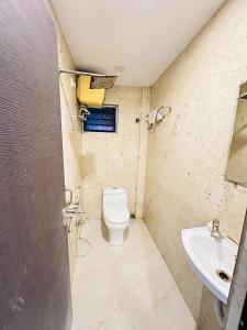 a bathroom with a toilet and a sink at Hotel Sunview in Kolkata +7 photos