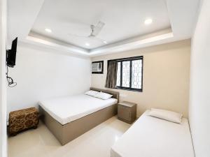 a bedroom with two beds and a window at Hotel Sunview in Kolkata