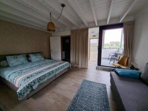 a bedroom with a bed and a living room at De Lokroep in Heers