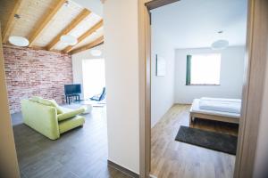 a living room with a couch and a bed in a room at Öregtölgy Apartman in Szár