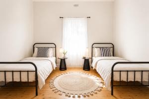 two beds in a room with a window at Central 3BR Heritage Home Walk to Sovereign Hill & CBD Free Parking in Ballarat