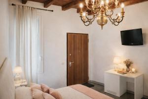 a bedroom with a bed and a chandelier and a door at Locanda Divinis in Cerea