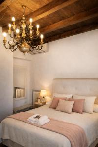 a bedroom with a large bed with a chandelier at Locanda Divinis in Cerea