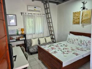 a small bedroom with a bed and a ladder at Sotera and Paz Forestville in Silang