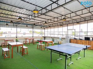 a room with tables and chairs and a ping pong table at Z Express Leela in Bangalore