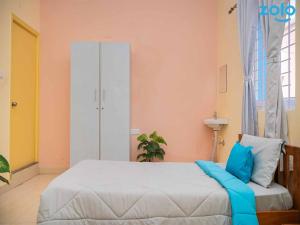 a bedroom with a bed with blue pillows at Z Express Leela in Bangalore