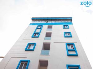 a tall white building with blue windows at Z Express Leela in Bangalore