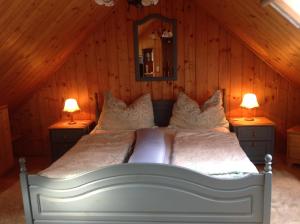 a bedroom with a bed with two lamps on two dressers at Ferienwohnung Jauk in Gleinstätten +26 photos