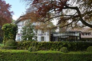 a large white house with a tree in front of it at Auberge aux 4 Vents in Fribourg