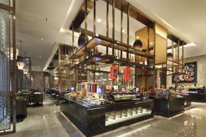 a restaurant with a counter with food on display at Wanda Vista Xining in Xining