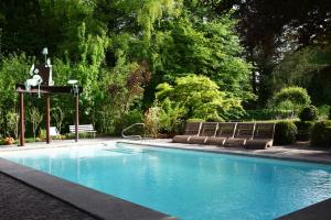 a swimming pool with two benches and a fountain at Auberge aux 4 Vents in Fribourg