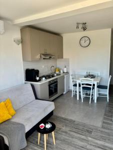 a living room with a couch and a kitchen with a table at Rural Apartment Ante in Drniš