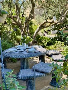 a blue table with dishes on it in a garden at Rural Apartment Ante in Drniš