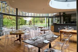 a restaurant with tables and chairs and large windows at Auberge aux 4 Vents in Fribourg