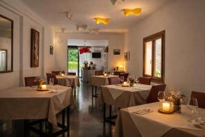 a restaurant with tables with white tablecloths and candles at Locanda Divinis in Cerea