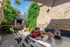 a table with food and an umbrella on a patio at Les Acacias in Colombiers