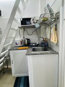 a small kitchen with a sink and a staircase at Căn Studio Áp Mái Full Nội Thất - Gần TTTM Aeon Tân Phú in Ho Chi Minh City