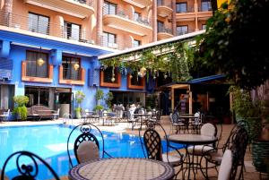 a pool with tables and chairs next to a building at Blue Sea Le Printemps in Marrakesh