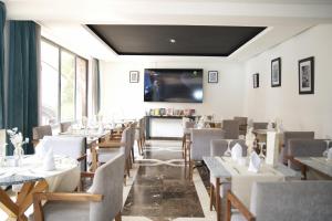 a restaurant with tables and chairs and a flat screen tv at Blue Sea Le Printemps in Marrakesh