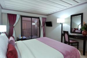 a bedroom with a bed and a desk and a mirror at Blue Sea Le Printemps in Marrakesh
