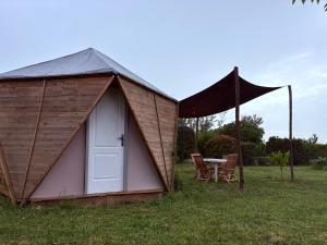 a small building with a table and a tent at Les Cabanes du Vigné in Molandier
