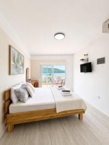 a bedroom with a large bed with a view of the ocean at Apartmani Villa Amfora - Free Parking in Neum
