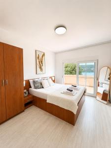 a bedroom with a large bed and a large window at Apartmani Villa Amfora - Free Parking in Neum
