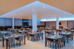 a restaurant with tables and chairs in a building at The Shore Trishvam in Pondicherry