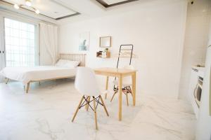 a white room with a table and a bed at Taean Sharon Pension in Taean