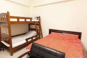 1 Schlafzimmer mit 2 Etagenbetten und einem schwarzen Ledersessel in der Unterkunft B-wei B&B in Hualien