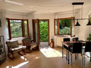 a living room with a table and chairs and windows at Appartement Zirbe in Rickenbach
