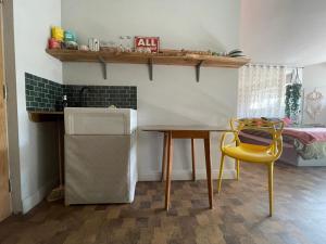 a kitchen with a table and a yellow chair at "The Studio" Contemporary studio with organic swimming pool in Skelsmergh