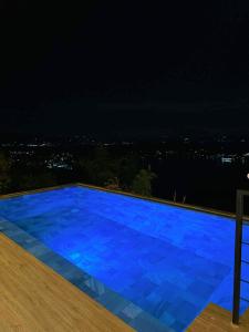 a large blue swimming pool at night at The LakeFront Villa in Binangonan