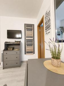 a room with a dresser and a television and a table at Decor in Atlantis Resort&SPA by RV Apartments in Burgas