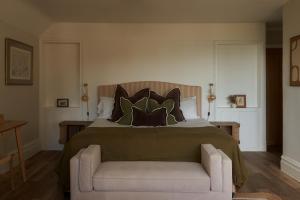 a bedroom with a large bed and a chair at Lulworth Lodge in Lulworth Cove +43 photos