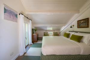 a bedroom with a large white bed with green pillows at La dolce riva - lake Cottage in Onno