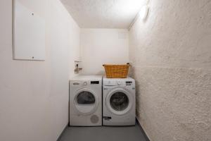 a laundry room with a washer and a washing machine at La dolce riva - lake Cottage in Onno
