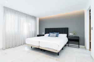 a bedroom with a white bed and a large window at Sunrise Center Suites in Torrevieja