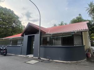 ein Haus, vor dem ein Motorrad geparkt ist in der Unterkunft Beevaa Inn in Fuvahmulah