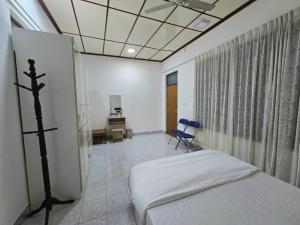 ein Krankenzimmer mit einem Bett und einem Schreibtisch in der Unterkunft Beevaa Inn in Fuvahmulah
