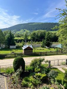 a park with a fence and a building in a field at Shum Cheremosha in Verkhovyna