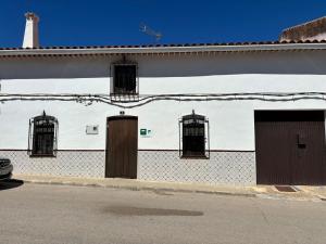 a white building with doors and windows on a street at Casa Rural SERAGAL in El Bonillo